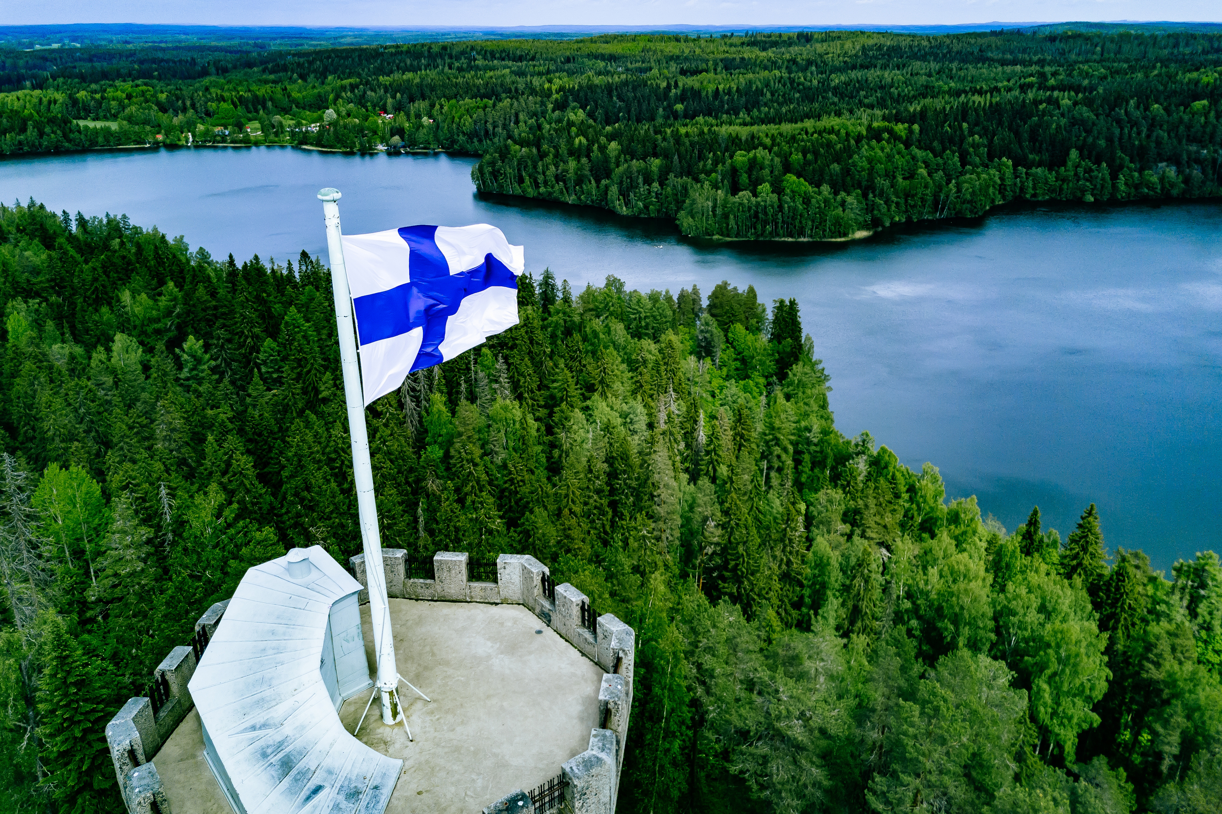 Финляндский флаг на фоне природы символизирующий гражданство Финляндии