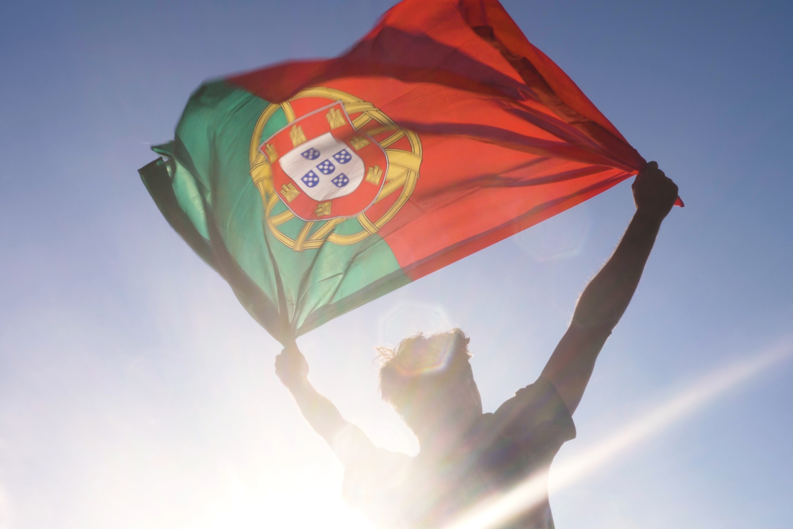 Португальский флаг развевающийся на ветру, символизирующий гражданство Португалии